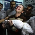 Foto simbolo della guerra a Gaza. Jihad Mashrawi, giornalista della BBC, tiene in braccio il corpo del figlio Omar, ucciso da un missile che colpì Gaza il primo giorno degli scontri tra israeliani e palestinesi nel novembre 2012 (AP Photo/Majed Hamdan, File)